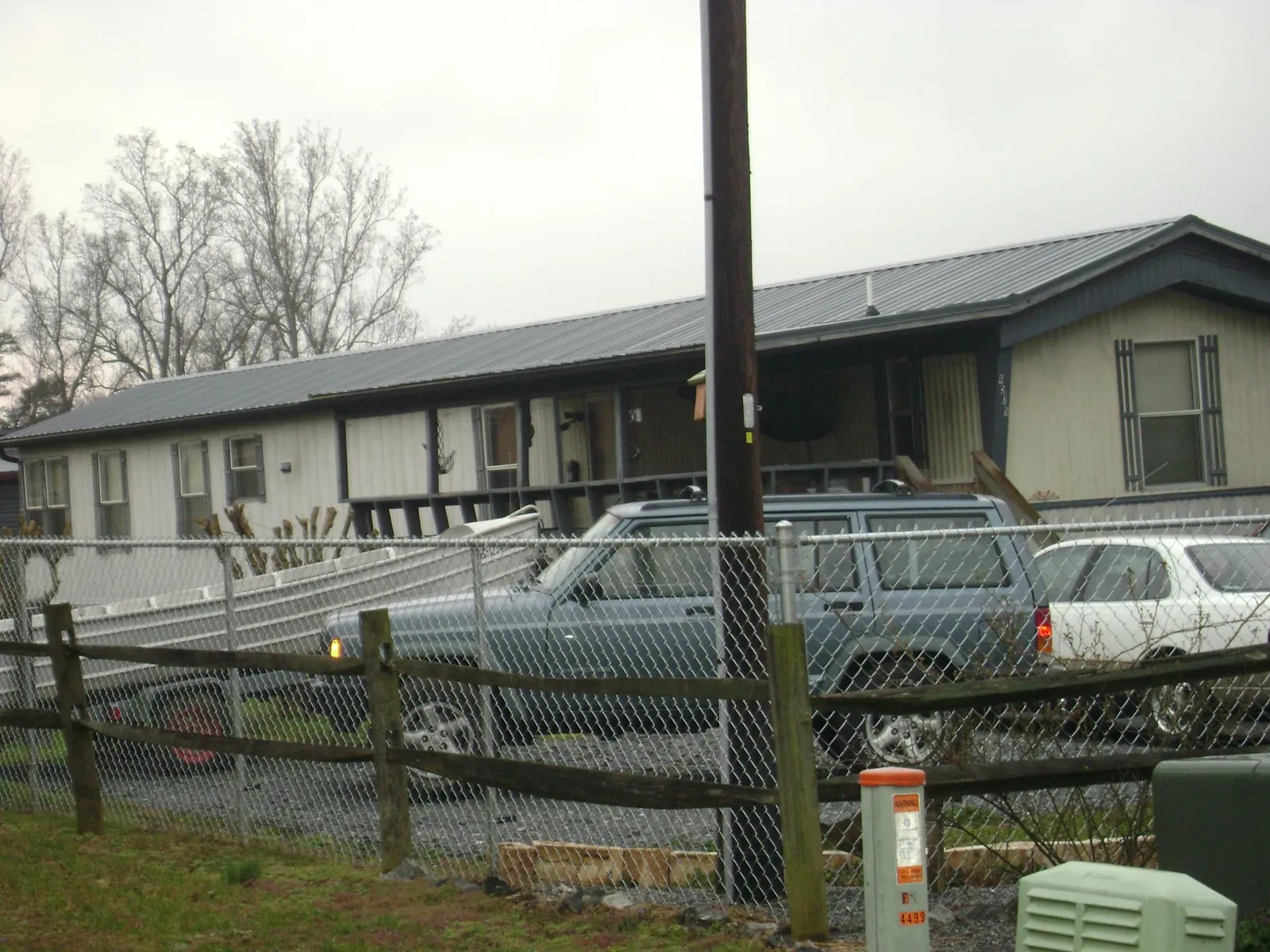 Dark metal roof on a long single story building behind a chain link fence in Princeton